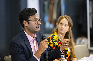 A photograph shows Rebekka Kesberg from the University of Sussex and Bharath Ganesh from the University of Amsterdam at the Brussels Democracy Dialogue 2025.